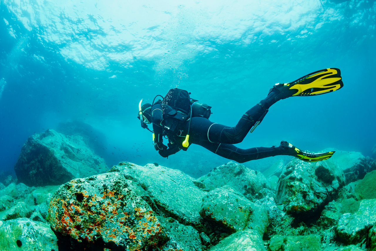 Scuba diving. Beautiful sea. Underwater scene with male scuba diver, enjoy  in blue, shallow water. Scuba diver point of view.